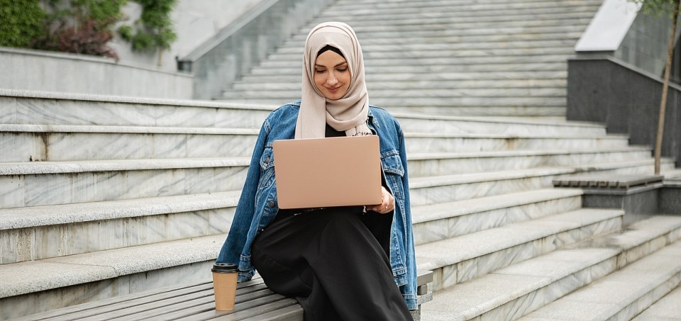 Woman on steps studying with her laptop computer